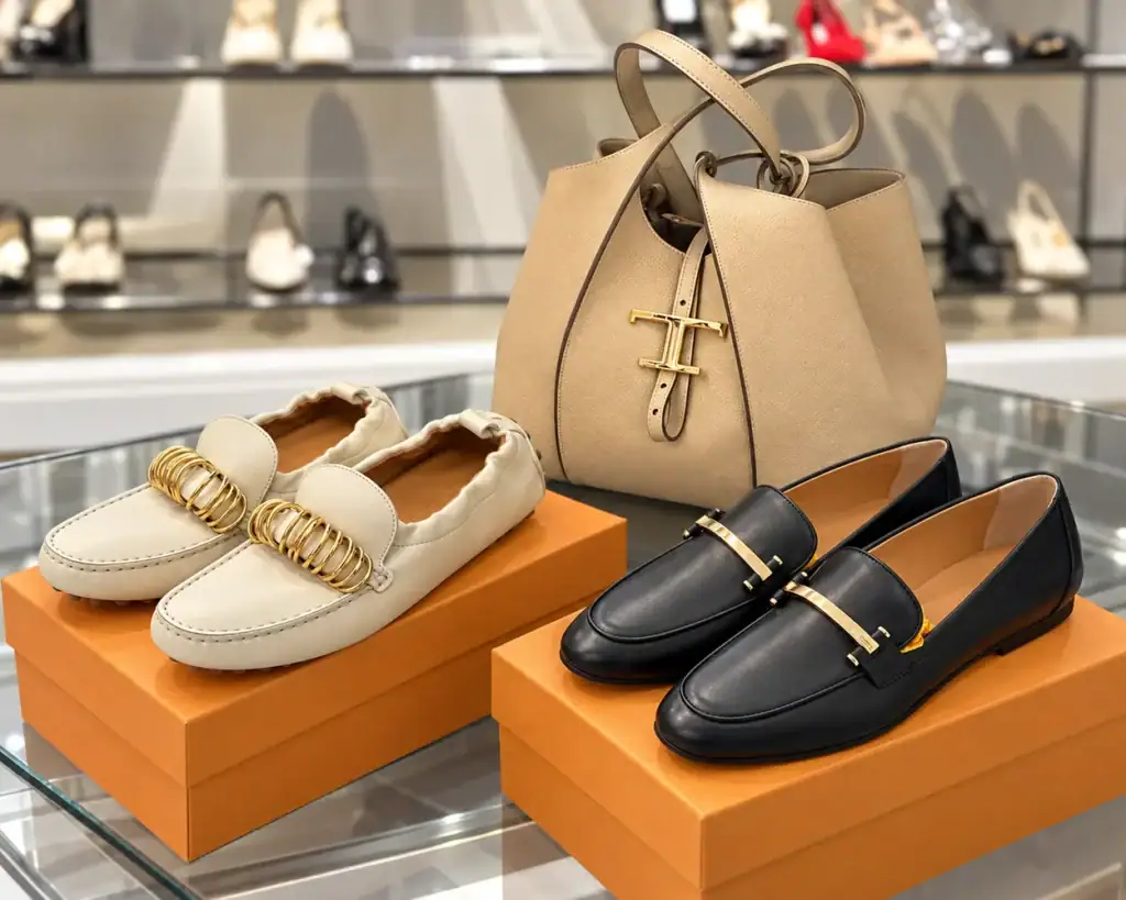 Итальянские обувные бренды - светлые мокасины и чёрные лоферы Tod’s рядом с бежевой сумкой
