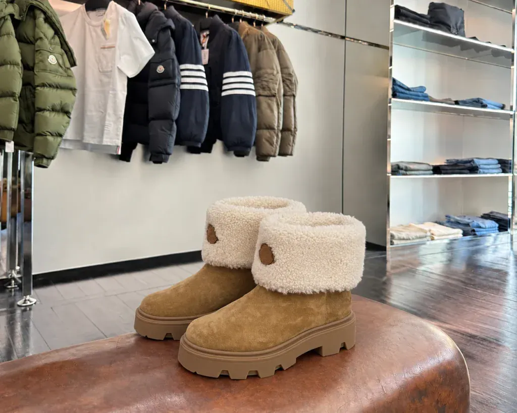 Moncler обувь оригинал из Италии - коричневые ботинки со светлыми фактурными отворотами на кожаной банкетке в бутике.