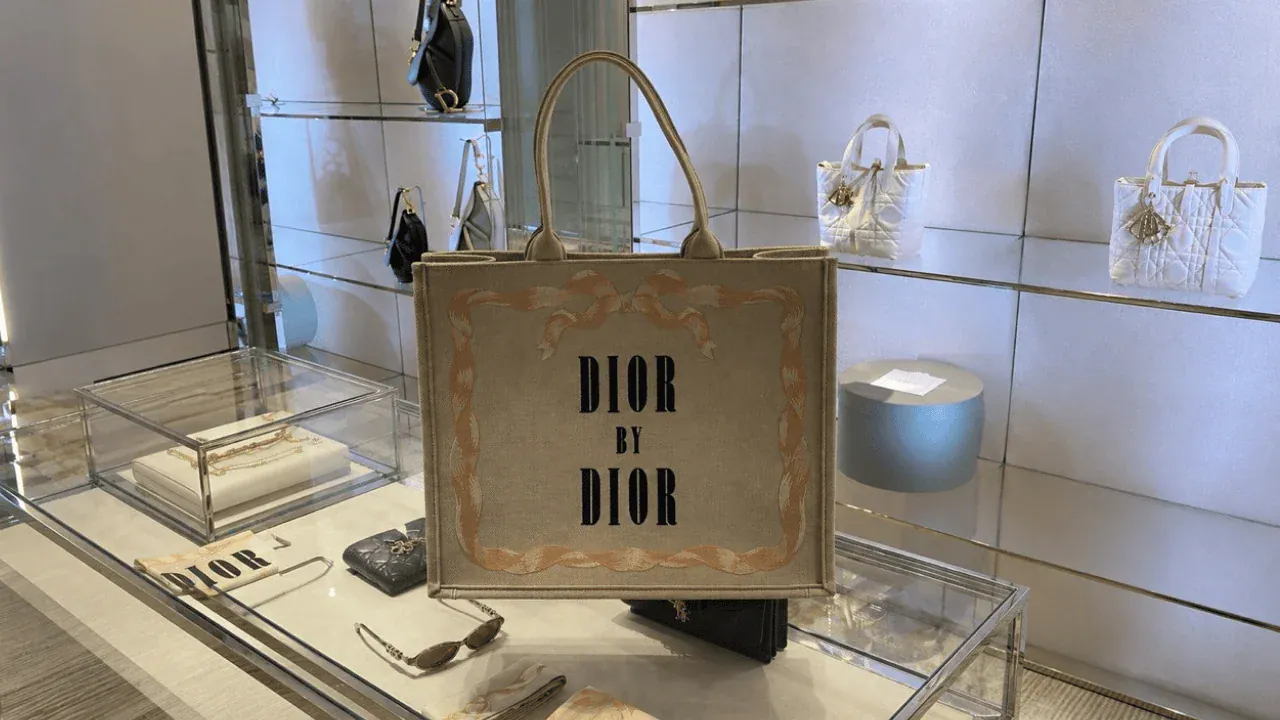 Почему сумки из Италии дешевле - сумка с надписью DIOR BY DIOR на стеклянной витрине бутика